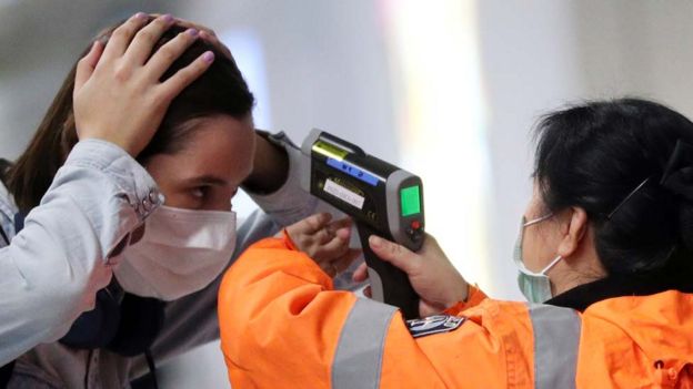 Woman's temperature being tested at an airport in Hong Kong