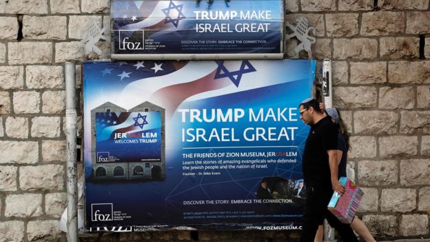 Israelis walk past a poster welcoming and supporting US President Donald Trump in Jerusalem, on May 19, 2017