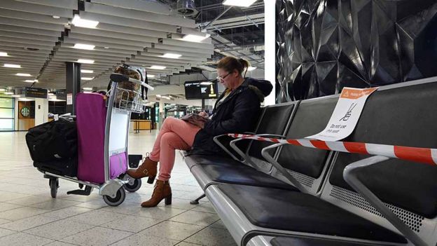 People wait to check-in at London Luton Airport as WizzAir starts to resume passenger flights on 1 May