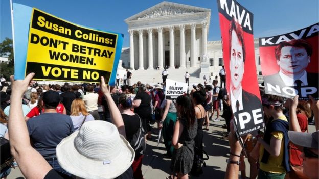 Protesters outside court holding signs, one saying: SUSAN COLLINS DON'T BETRAY WOMEN, VOTE NO.