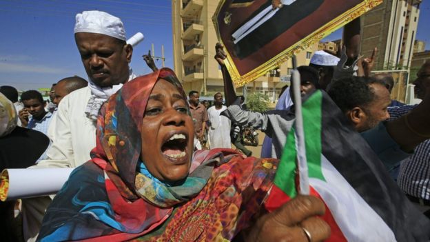 Supporters of Bashir holding signs