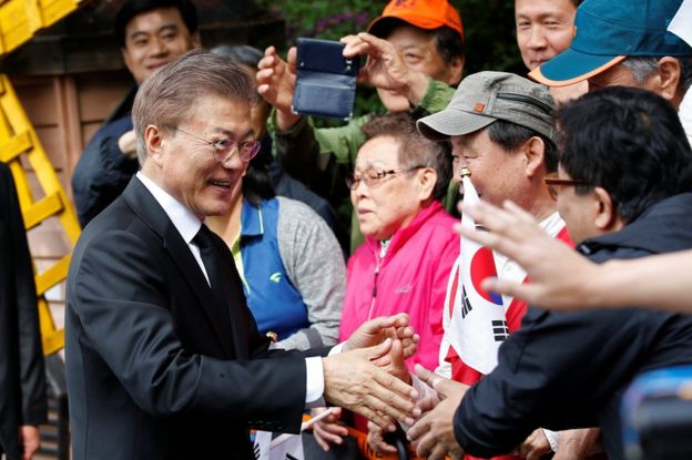 South Korea's President Moon Jae-in greets his supporters and neighbours as he leaves his house in Seoul, South Korea 10 May 2017