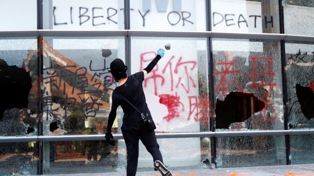 Protester throwing brick at a building