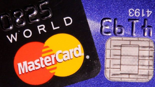 A MasterCard credit card is pictured next to a computer chip on a bank card