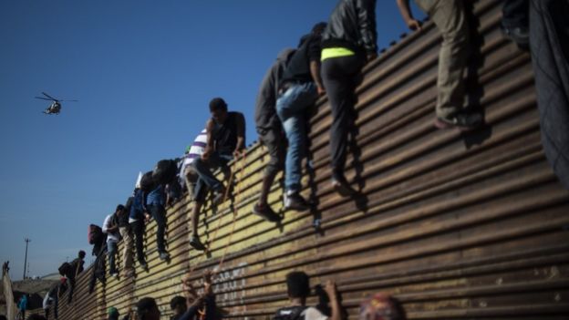 A group of Central American migrants -mostly Hondurans- climb the border fence between Mexico and the United States, near El Chaparral border crossing, in Tijuana, Baja California State, Mexico, on November 25, 2018.