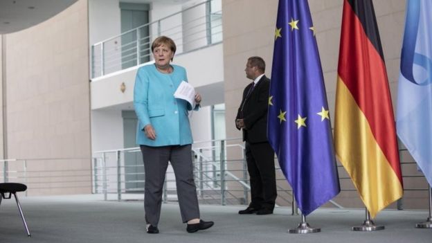 La canciller alemana Angela Merkel (izq.) Llega a hablar con los medios de comunicación tras una reunión virtual del Consejo Europeo, durante la pandemia de coronavirus en Berlín, Alemania, el 19 de agosto de 2020.