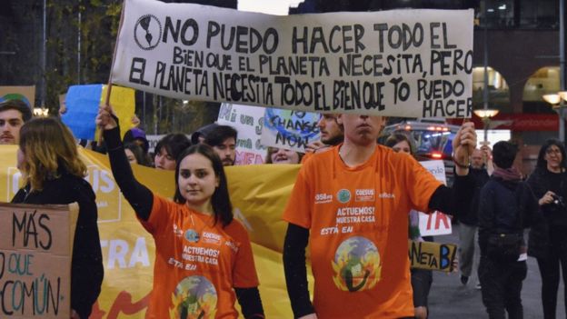 Ariana Palombo con un cartel que dice "No puedo hacer todo el bien que el planeta necesita, pero el planeta necesita todo el bien que yo pueda hacer".