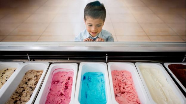 Un niño frente a una nevera de helados