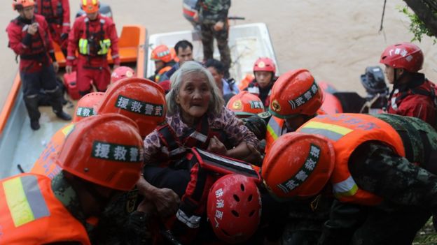 Police officers evacuate trapped people from a flood-hit area in southern China