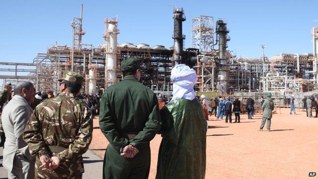 Algerian soldiers and officials stand in front of the gas plant in In Amenas