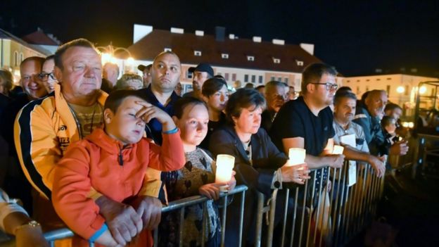 People held candles to mark the occasion at the ceremony in the city of Wielun, Poland