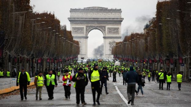 Manifestantes vestidos com coletes amarelos - peça de segurança obrigatória nos carros franceses - protestam em frente ao Arco do Triunfo