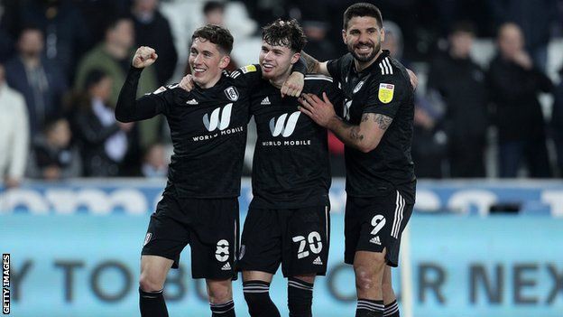 Neco Williams of Fulham celebrates scoring their sides fourth goal of the game with Harry Wilson and Aleksandar Mitrovic during the Sky Bet Championship match between Swansea City and Fulham at Swansea.com Stadium