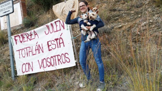 MUlher com cães e faixas próximo à área de resgate na Espanha