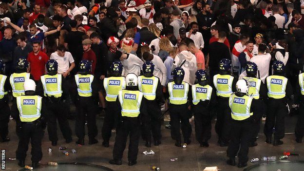 Police standing in front of England fans at Wembley