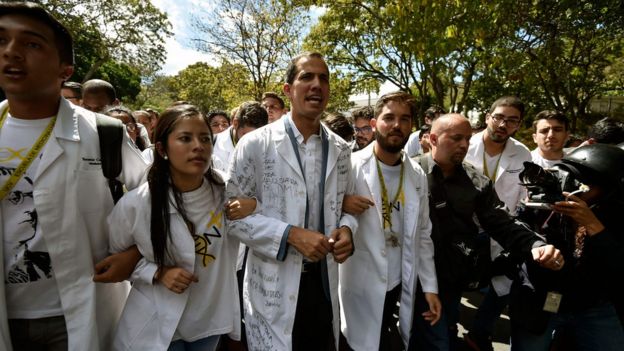 Opposition leader and self-proclaimed "acting president" Juan Guaido (C), chants slogans as he marches with students during a protest he convened against the government of President Nicolas Maduro