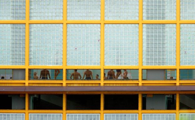 Por frestas, é possível ver alguns presos dentro de prisão de Changi