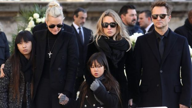 In this file photo taken on December 9, 2017, the son of late French singer Johnny Hallyday, David Hallyday (1st-R), daughter Laura Smet (2nd R), wife Laeticia (4th-R), their daughters Jade (5th-R) and Joy (3rd-R) stand by the coffin outside at the Eglise de la Madeleine.