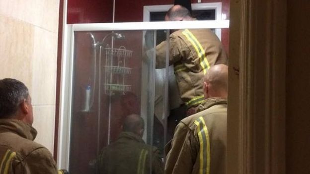 Los miembros del Servicio de Bomberos y Rescate de Avon en acción, tratando de sacar a la mujer atrapada en la ventana.