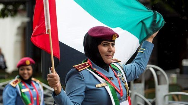 Police officer waves a flag while on parade in Cardiff