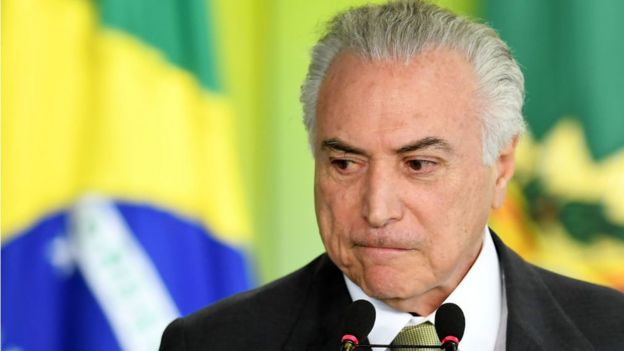 Temer tras una bandera brasileña