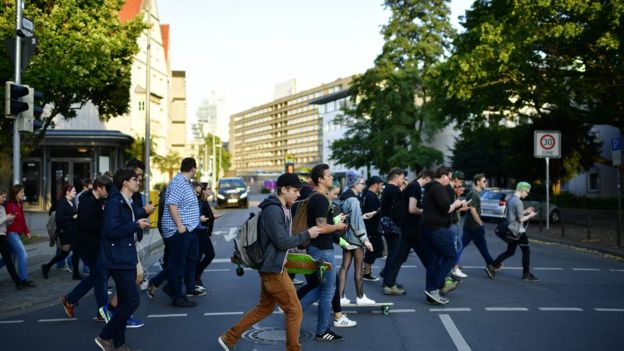 Jóvenes caminan prestando atención al celular y no a la calle.