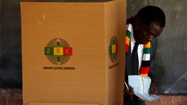 President Emmerson Mnangagwa checks his papers as he casts his ballot to vote in the country"s general election, at Sherwood Park Primary School in Kwekwe, Zimbabwe July 30, 2018.