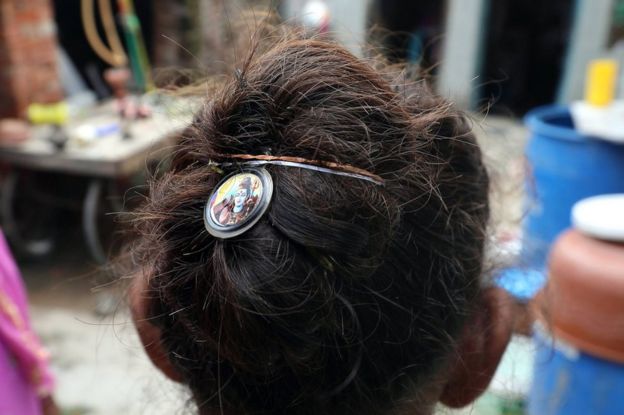 An Indian girl places a photo of Hindu god Shiva on her hair for protection after various women got their braids chopped off allegedly by unknown person in Kanganheri village, the outskirts of Delhi, India, 01 August 2017