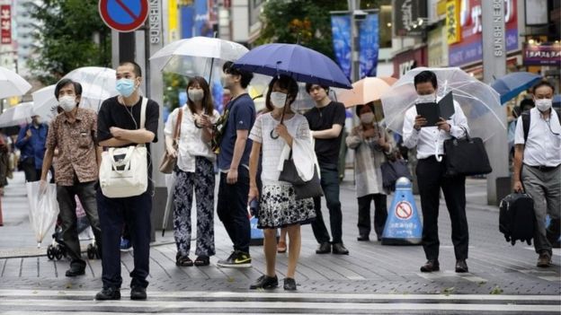 People in Tokyo wear masks at a crossing