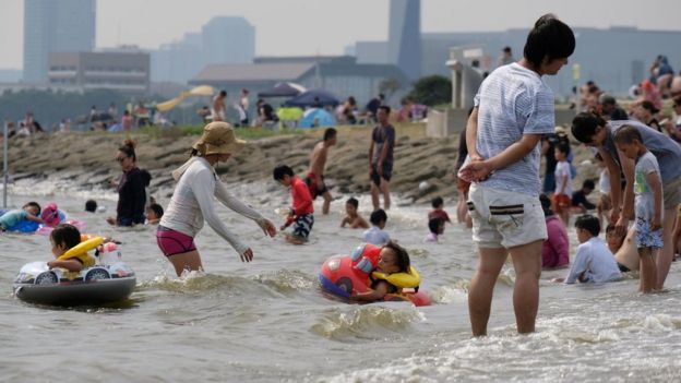 Families swim at a seaside park in Tokyo on July 22, 2018 as a severe heatwave continues