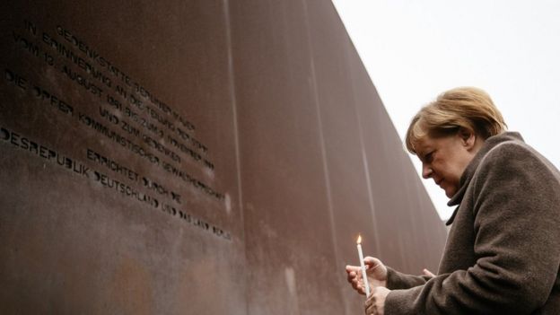 German Chancellor Angela Merkel brings a candle during the celebrations of the 30th anniversary of the fall of the Berlin Wall at the Berlin Wall Memorial site along Bernauer street in Berlin, Germany, 09 November 2019