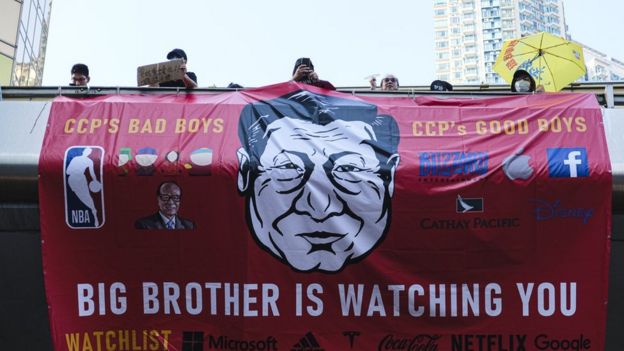 Una pancarta de protesta con una caricatura de Xi Jinping y el eslógan "gran hermano te vigila".