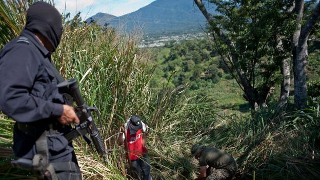 Policía mira una exhumación en El Salvador