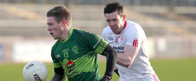 Michael Monan of Queen's and Tyrone's Conor Clarke contest for possession at Healy Park