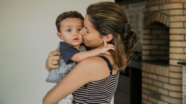Imagem mostra Guilherme, de 1 e 4 meses, nos braços da mãe, a nutricionista Michelle Costa