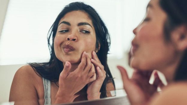 Una mujer viéndose en el espejo