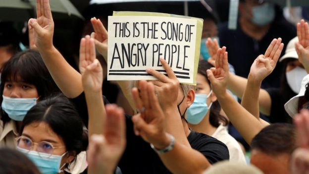 A protester holds a sign while doing a three-fingered salute during a demonstration to demand the release of activist leaders in Bangkok, Thailand August 8, 2020
