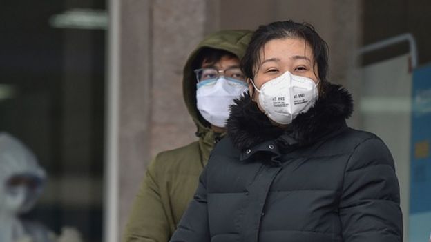 People wearing protective facemasks stand outside the Wuhan Fifth Hospital in Wuhan, China