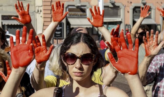 Protesters of Italys Radical Party with their hands painted red during a protest against the Italian Interior Minister Matteo Salvini