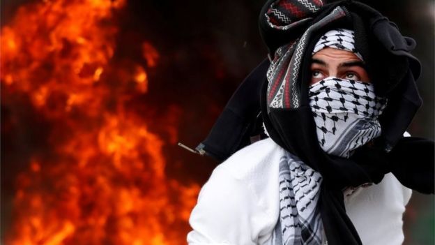 Masked Palestinian in front of flames in Ramallah (20/12/17)