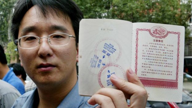 Hombre chino mostrando su pasaporte