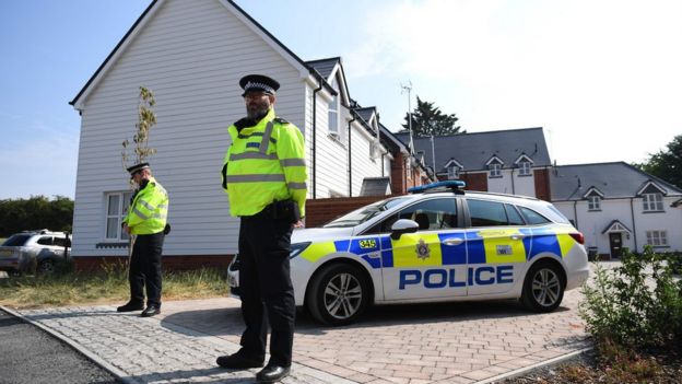 Police officers are seen standing guard outside a residential address in Amesbury