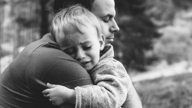 Un padre con su hijo llorando