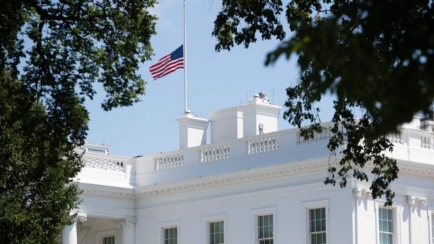 The American flag flies at half staff over the White House in Washington, DC, July 18, 2020