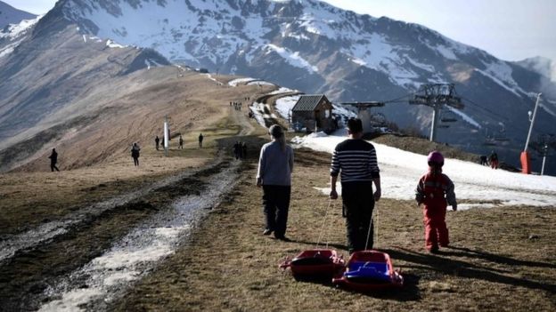 People pull a sled on the top of a ski slope near Luchon, in French Pyrenees