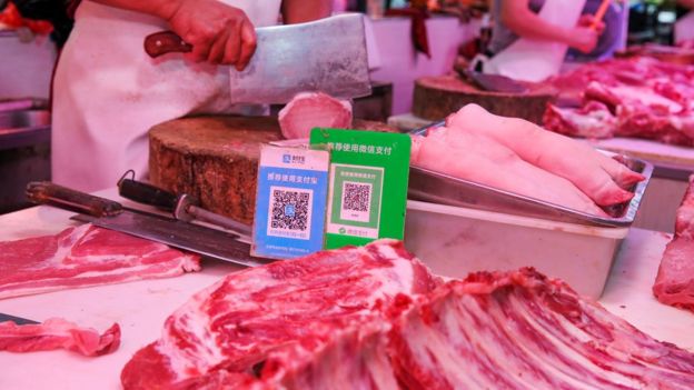 Alipay and wechat QR codes for online payment are displayed at a meat stall at a market in Nantong in China's eastern Jiangsu province on September 10, 2018.