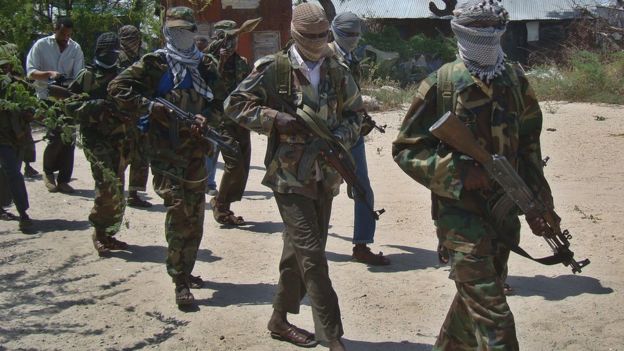 Militants in al-Shabab walk down a street in Mogadishu, Somalia