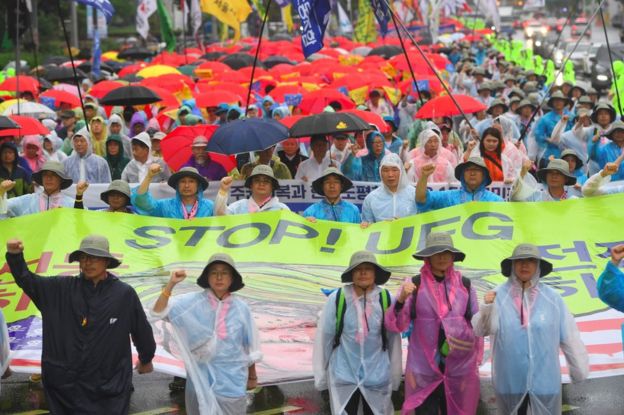 South Korean protesters hold a banner reading 