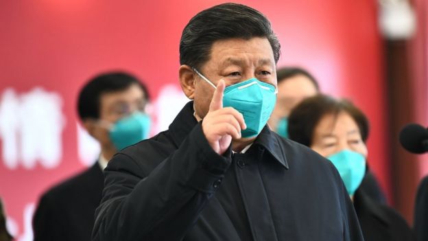 Chinese President Xi Jinping wearing a mask as he GESTURES to a coronavirus patient and medical staff via a video link at the Huoshenshan hospital in Wuhan