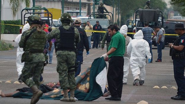 Militares mexicanos y personal forense en una escena de crimen en la ciudad de Nuevo Laredo, estado de Tamaulipas.